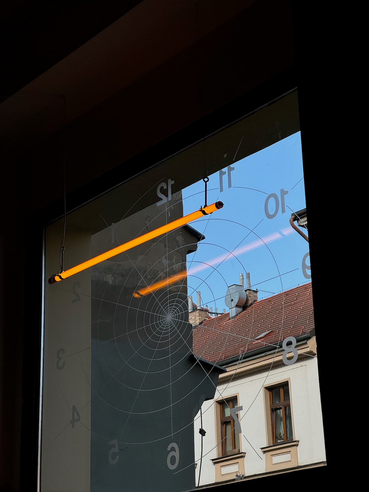 Interiér Tempa — výloha s grafikou ciferníku a neonovou zářivkou