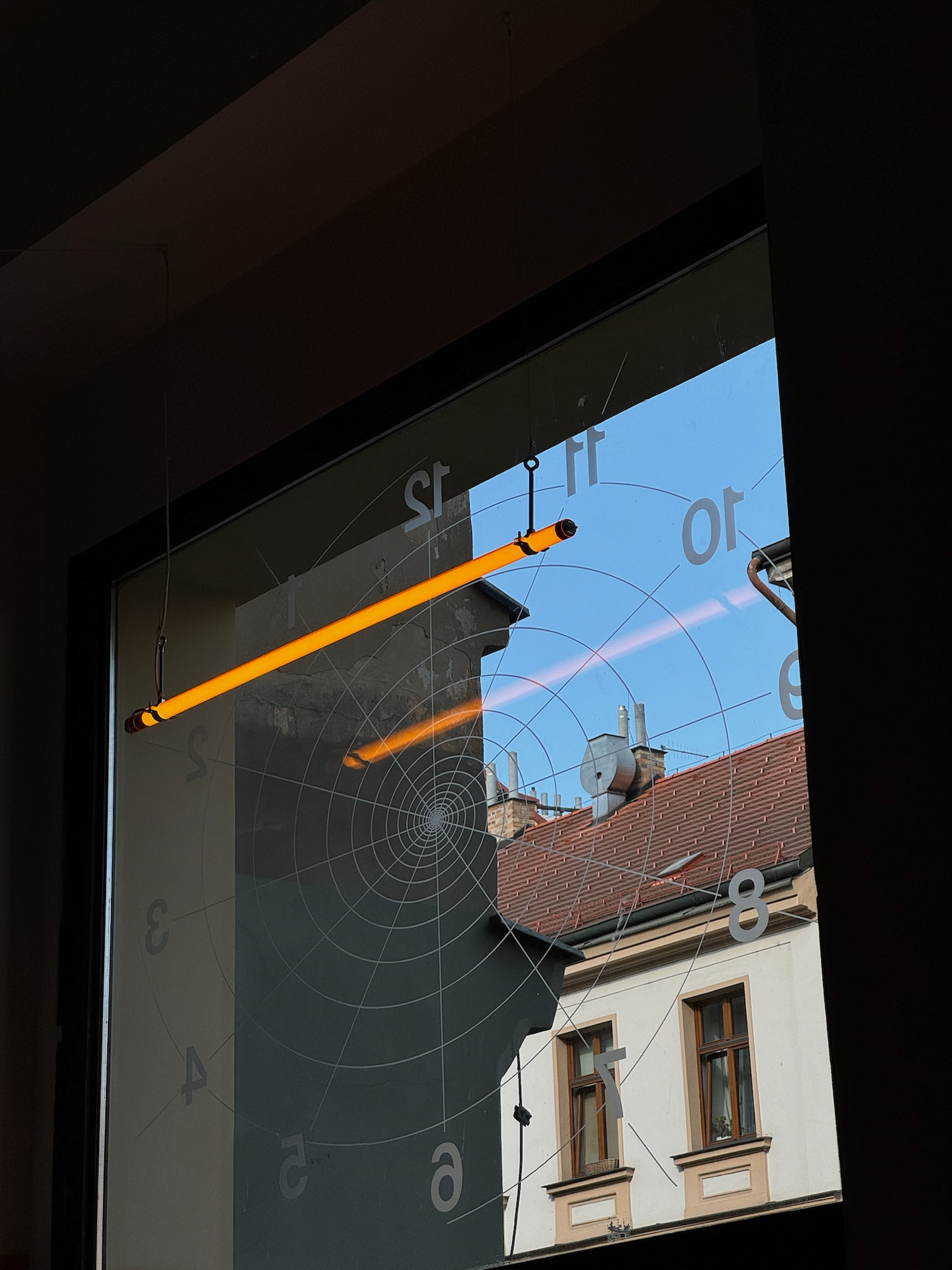 Interiér Tempa — výloha s grafikou ciferníku a neonovou zářivkou